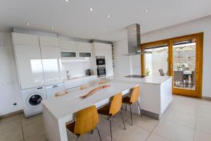 een keuken met een wit aanrecht en stoelen. bij Catalunya Casas Modern Magnificence , only a few km to the beach! in Sant Cebrià de Vallalta