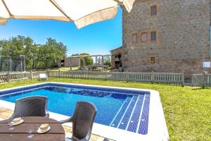 uma piscina com mesa e cadeiras ao lado de um edifício em Catalunya Casas Rustic Catalan countryside villa with private pool! em Peracamps