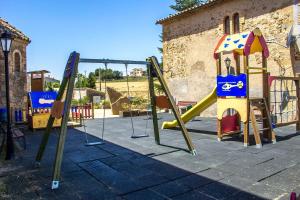 um parque infantil com um escorrega e um baloiço em Catalunya Casas Rustic Catalan countryside villa with private pool! em Peracamps