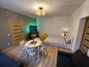a small room with a table and a bed at Wood Apartment z Konsola X-Box in Katowice