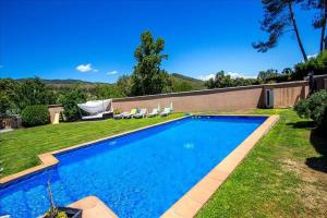 einen Pool in einem Garten mit zwei Gartenstühlen in der Unterkunft Catalunya Casas Modern and spacious with private pool close to BCN in Senmanat
