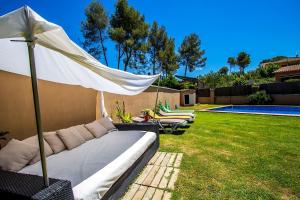 un sofá con sombrilla en un patio en Catalunya Casas Modern and spacious with private pool close to BCN, en Senmenat