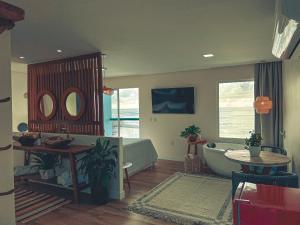 a living room with a bath tub and a table at Sollaris Ecopousada in Japaratinga
