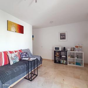 uma sala de estar com um sofá e uma mesa em Apartment Las Arenas - Las Casas de Aron em Caleta De Fuste