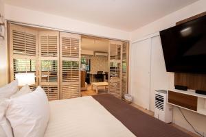 a bedroom with a bed and a flat screen tv at La mejor Garden Suite Privada del complejo Coronado Luxury Club and Suites in Playa Coronado