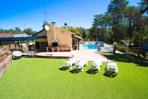 サンタ・コロマ・デ・ファルネルスにあるCatalunya Casas Costa Brava villa with private pool & spacious gardenの庭の芝生の椅子とテーブル