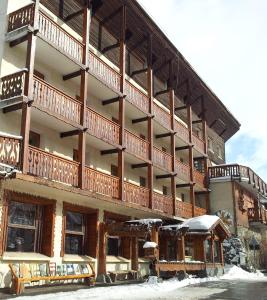 un grand bâtiment avec des balcons sous la neige dans l'établissement Centre de Vacances Le Val d'Escreins, à Vars