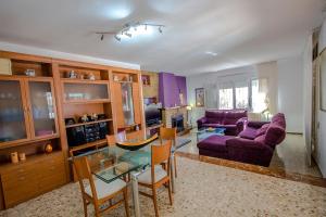 a living room with a purple couch and a glass table at Catalunya Casas Beach Vibes Villa less than 1km to town and sea! in Hospitalet de l'Infant