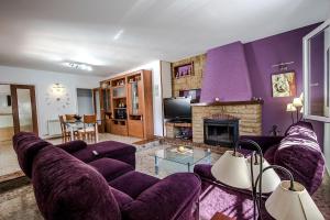 a living room with purple furniture and a fireplace at Catalunya Casas Beach Vibes Villa less than 1km to town and sea! in Hospitalet de l'Infant