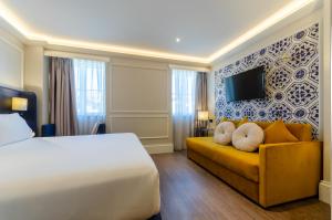 une chambre d'hôtel avec un lit et un canapé dans l'établissement Eurostars Lisboa Baixa, à Lisbonne