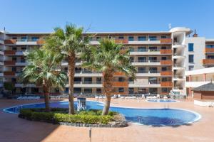 basen z palmami przed budynkiem w obiekcie Balcon de los Gigantes with pool view w mieście Puerto de Santiago