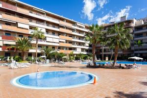 basen przed budynkiem z palmami w obiekcie Balcon de los Gigantes with pool view w mieście Puerto de Santiago