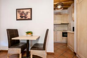 a small kitchen with a table and chairs in a room at The Varos Residences Hotel in Város