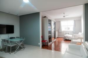 sala de estar con mesa, sofá y TV en Apartamento confortável na quadra da praia, en Río de Janeiro
