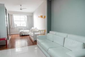sala de estar con sofá blanco y mesa en Apartamento confortável na quadra da praia, en Río de Janeiro