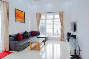 a living room with a couch and a table at S1 VILLA - SunHill Villa in Vung Tau