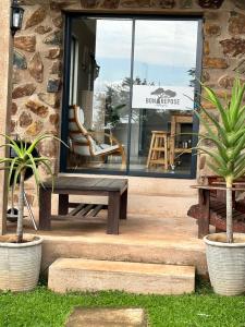 a bench sitting in front of a store window at Hazyview Accommodation, Bon Repose Cottage 2 in Hazyview
