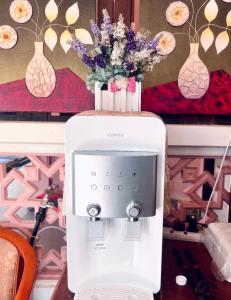 a vase of flowers sitting on top of a machine at Kenangan Inn in Pantai Cenang