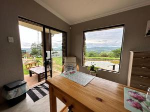 a room with a desk and a large window at Hazyview Accommodation, Bon Repose Cottage 2 in Hazyview