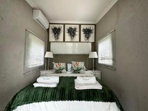哈玆維尤的住宿－Hazyview Accommodation, Bon Repose Cottage 2，一间卧室设有两张床和两个窗户。
