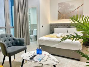 a bedroom with a bed and a chair and a table at Tennessee Urban Suites in Málaga