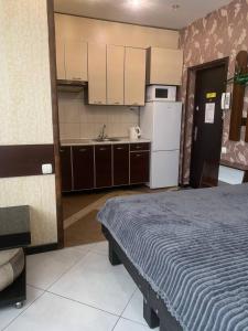 um quarto com uma cama e uma cozinha com electrodomésticos brancos em Na Bukovinskoy Guest House em Kharkov