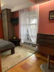 a bedroom with a window with a bench and a table at Na Bukovinskoy Guest House in Kharkiv