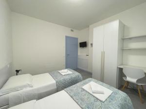 Un dormitorio con dos camas y un escritorio y una silla. en Villa Rubino, en Padenghe sul Garda