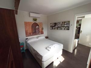 sypialnia z białym łóżkiem i ceglaną ścianą w obiekcie ÁTICO SANTA MARÍA w Kadyksie
