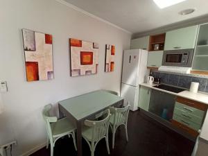 kuchnia ze stołem, krzesłami i lodówką w obiekcie ÁTICO SANTA MARÍA w Kadyksie