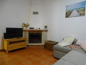 a living room with a couch and a flat screen tv at Lodge & Hike Almograve 2 in Almograve
