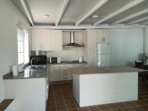 a kitchen with white cabinets and granite counter tops at Casa Rural La Maestra in Ronda