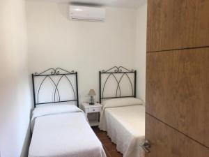 a bedroom with two beds and a night stand at Casa Rural La Maestra in Ronda