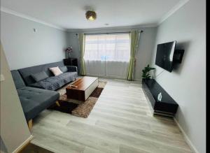 a living room with a couch and a tv at Sweet four bedroom home @cranbourne west in Cranbourne West