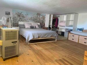 1 dormitorio con 1 cama en una habitación con suelo de madera en Charmant petit appartement proche du pic St loup, en Le Triadou