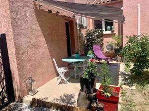 un pequeño patio con mesa y sillas frente a un edificio en Charmant petit appartement proche du pic St loup, en Le Triadou