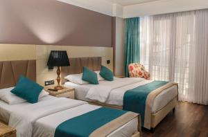 a hotel room with two beds and a window at Hotel Bossuite Kadikoy in Istanbul