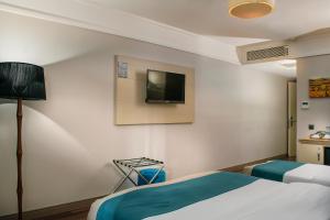 ein Hotelzimmer mit einem Bett und einem TV an der Wand in der Unterkunft Hotel Bossuite Kadikoy in Istanbul