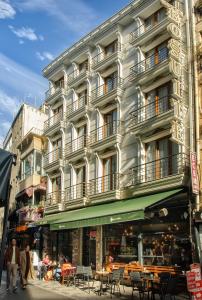 a tall white building with people walking in front of it at Hotel Bossuite Kadikoy in Istanbul