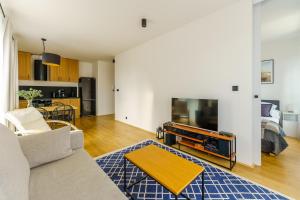 a living room with a couch and a flat screen tv at Apartament SEAGRASS SurfingBird Dźwirzyno in Dźwirzyno