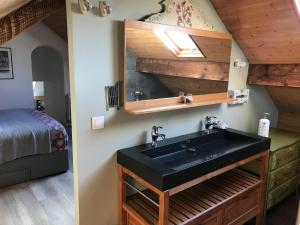 a bathroom with a black sink and a bed at Appartement Cosy Chelles in Chelles