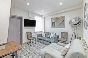 a living room with a couch and two chairs at 3 Bedroom Holiday House in Liverpool