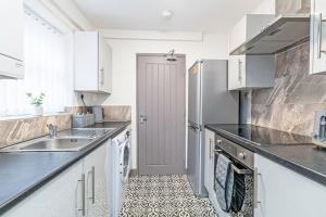a kitchen with a sink and a refrigerator at 3 Bedroom Holiday House in Liverpool