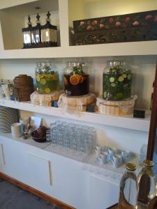 a shelf with jars of food and other items on it at The Varos Residences Hotel in Város