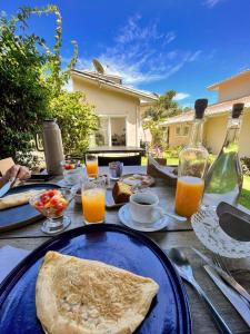 stół z niebieskim talerzem jedzenia i soku pomarańczowego w obiekcie Parador Búzios Boutique Hotel w mieście Búzios