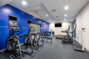 einen Fitnessraum mit Kardiogeräten und einer blauen Wand in der Unterkunft Holiday Inn Express & Suites Wadsworth, an IHG Hotel in Wadsworth