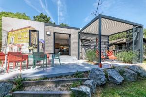 Cette maison dispose d'une terrasse avec une table et des chaises. dans l'établissement Nantes Camping Le Petit Port, à Nantes