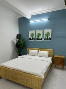 - une chambre avec un lit dans un mur bleu dans l'établissement Q House- Green Villa Quy Nhơn, à Quy Nhơn