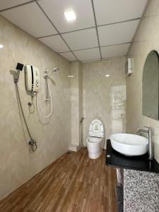 ein Bad mit einer Dusche, einem WC und einem Waschbecken in der Unterkunft Q House- Green Villa Quy Nhơn in Quy Nhon