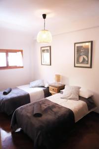 a room with three beds and a pendant light at Apartamento La Campa in Canfranc-Estación